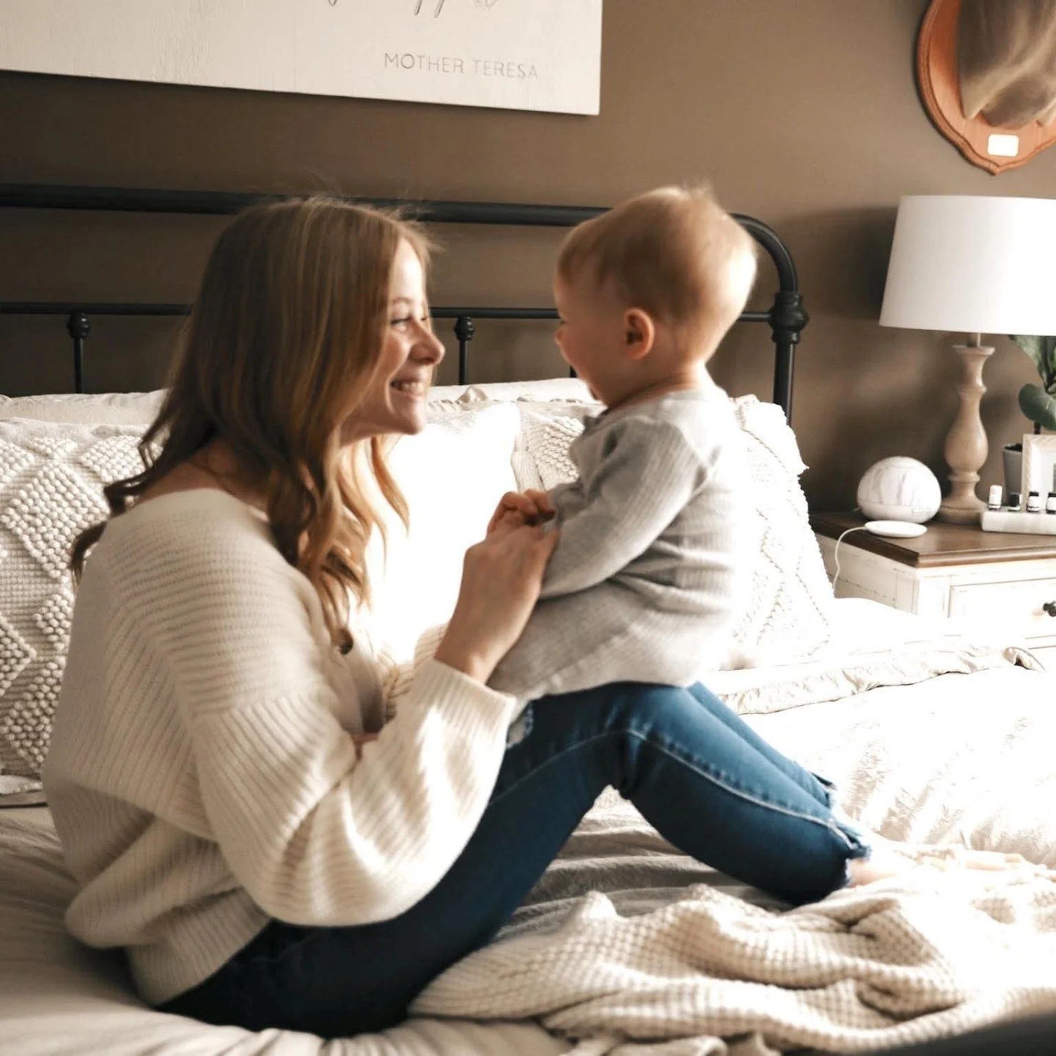 Mother and baby sharing a happy moment on a customer's bed